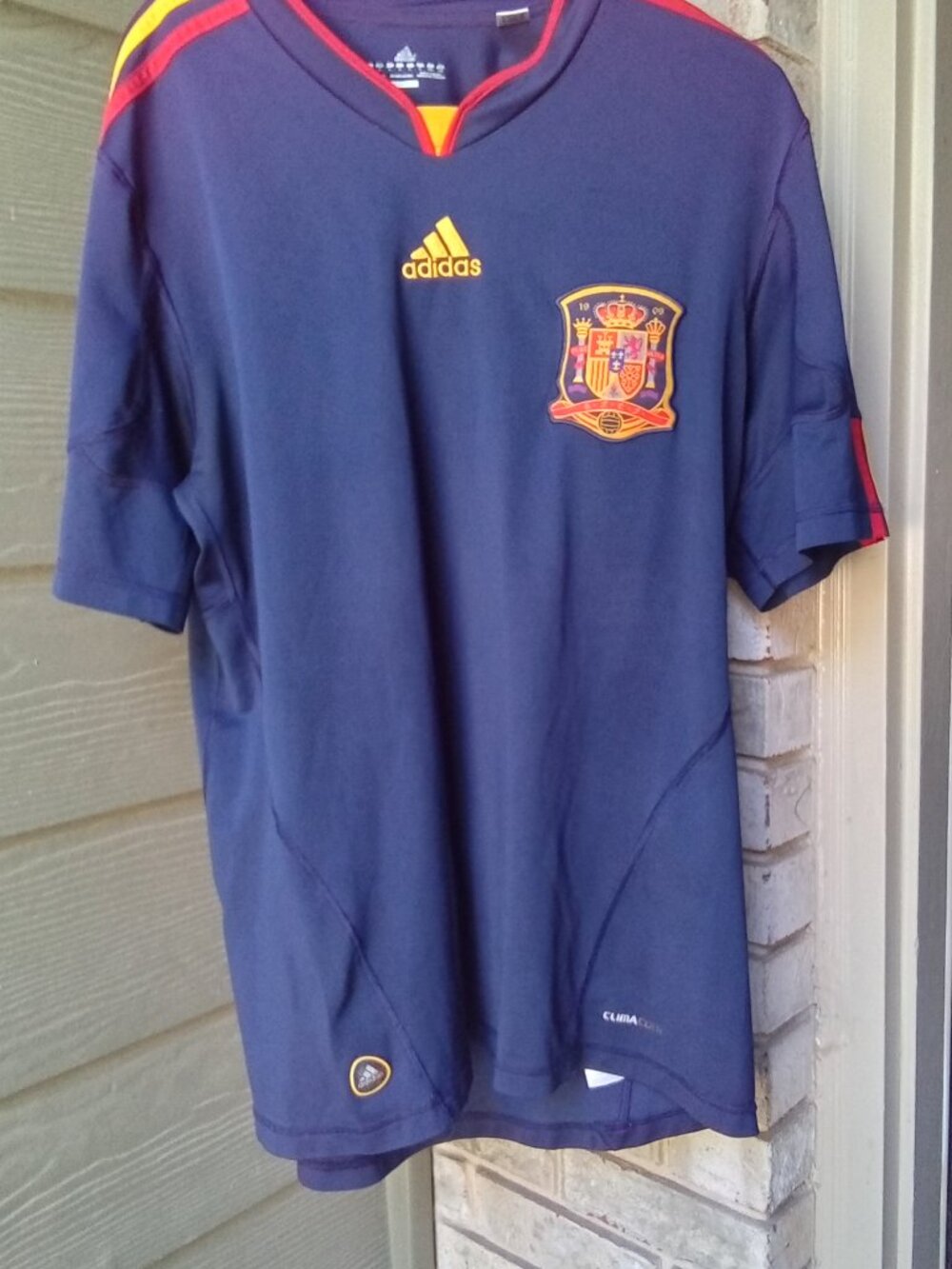 The product is a 2010-2011 Spain soccer football jersey by adidas,